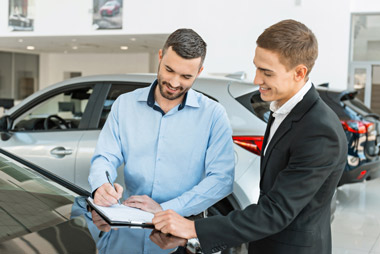Momento feliz de la firma del contrato tras la decisión de comprar un coche nuevo. Momento feliz de la firma del contrato tras la decisión de comprar un coche nuevo