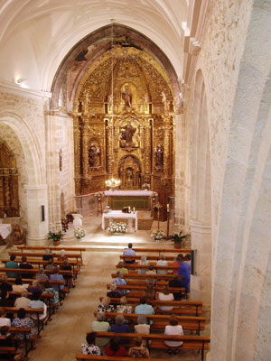 Nave central de la parroquia, con el retablo al fondo. Interior de la Iglesia