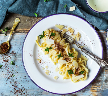 Chitarrine con salsa de Parmesano, pimienta rosa e hierbas aromáticas